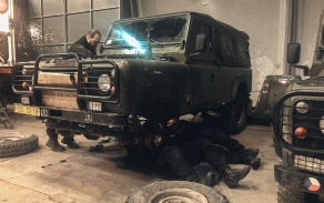 Mechanici během výměny spojky u vozidla landrover.